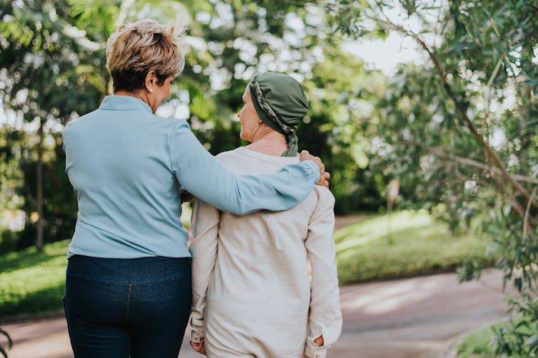 Two women walking arm in arm
