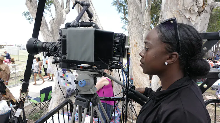 A woman at a camera.