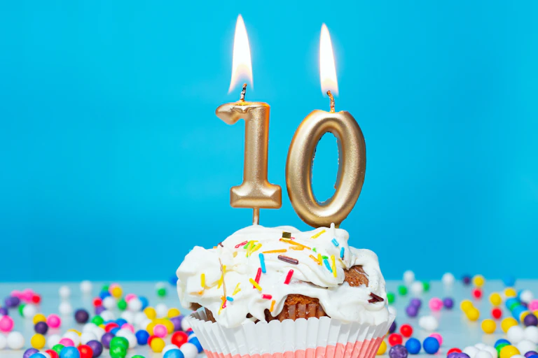 un gâteau d'anniversaire avec des bougies dorées indiquant le chiffre 10