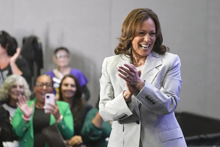 Harris stands, laughing in front of supporters