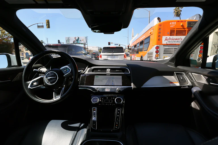 view looking forward from the back seat of a car in traffic with noone in the front seats