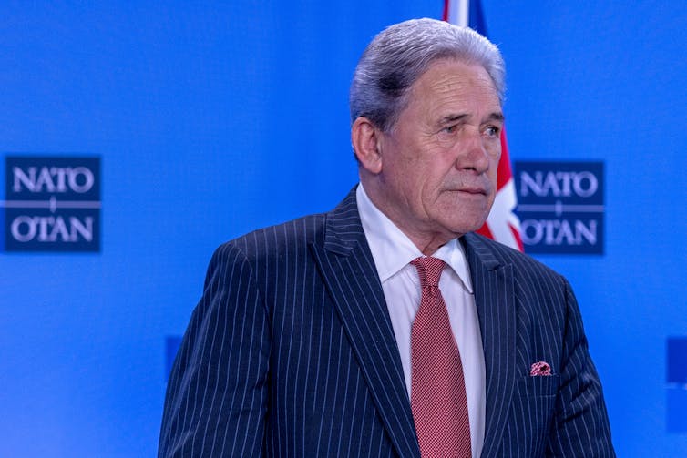 Winston Peters with NATO signage behind him