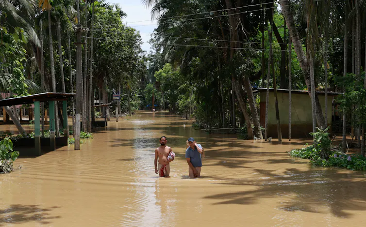 Men walking through floodwater.