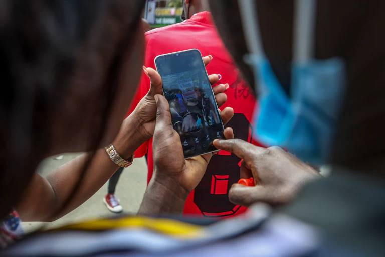 Two people photographed from behind using a cellphone