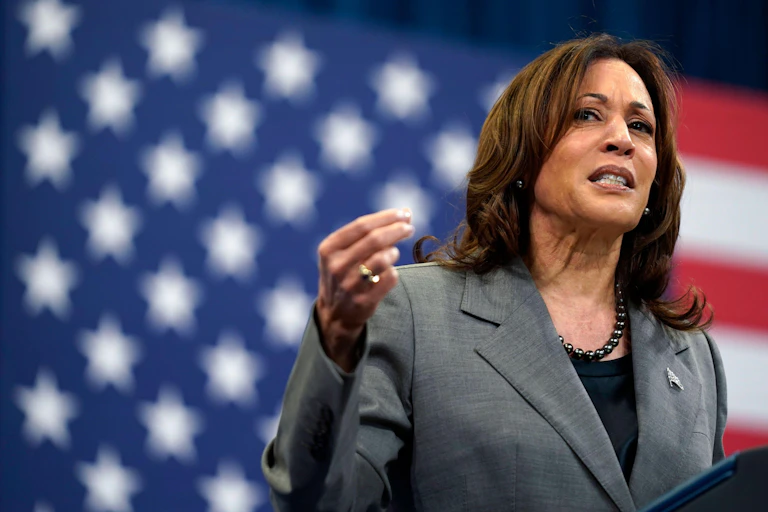 Kamala Harris at a podium in front of a US flag.