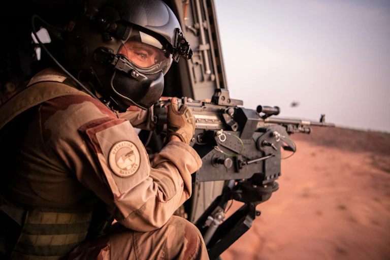 Militaire en uniforme de l'opération Barkhane tenant une mitrailleuse