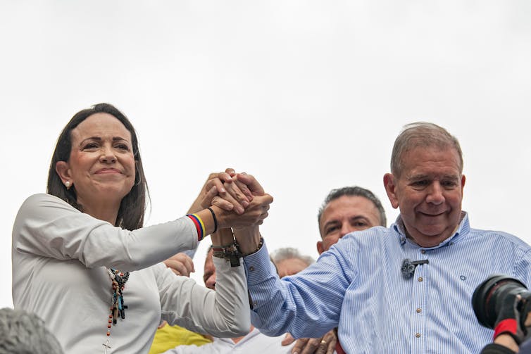 A man and woman link hands.