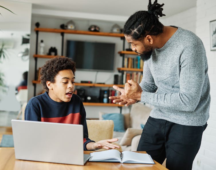 Father talking to child on laptop.