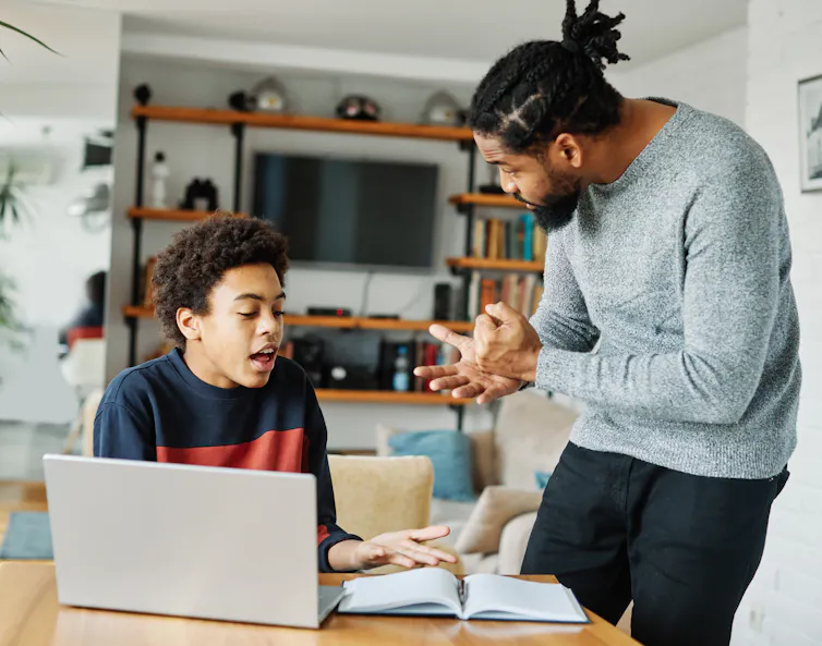 Dad talks to child on laptop