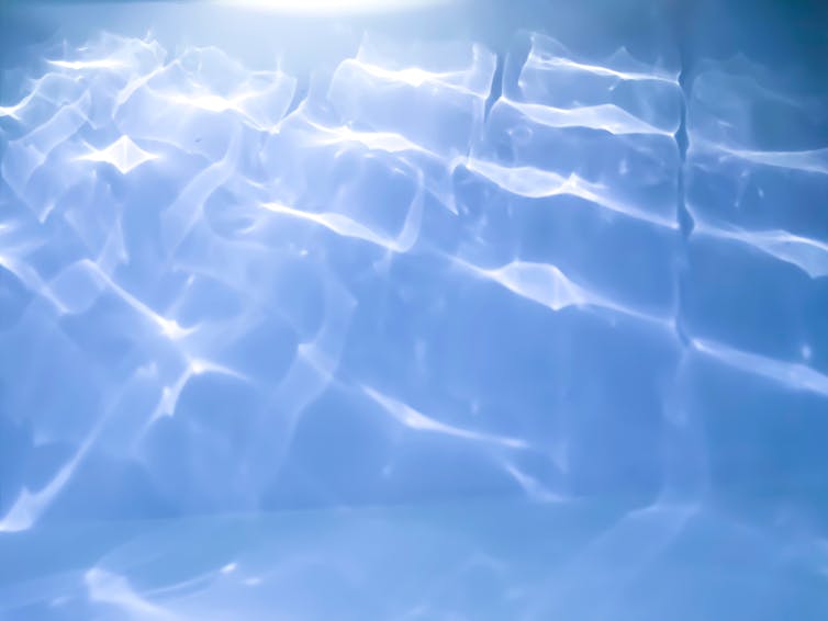 Photo of ripples on the surface of a swimming pool.