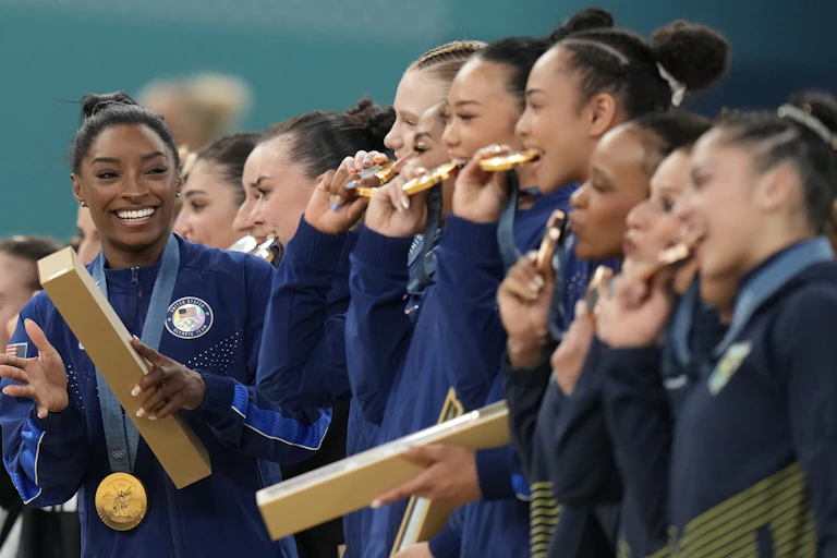 Simone Biles and her US team celebrate after winning gold in Paris.