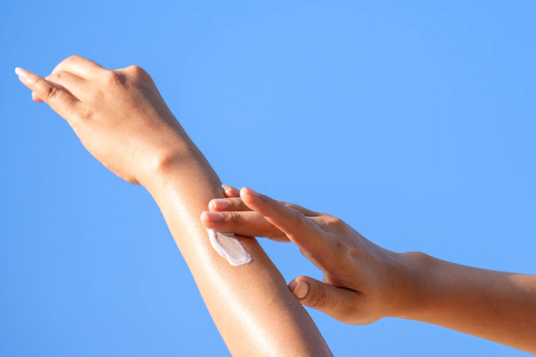 Gros plan d'une femme se passant de la crème solaire.