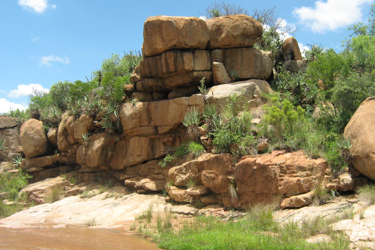 Naturally stacked big rocks on top of each other next to a flowing river