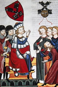 Colorful painting of a man dressed in robes holding out his hands before four people.