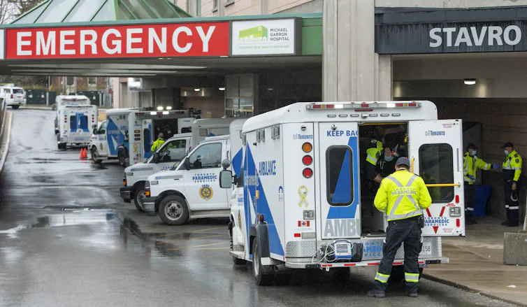 Paramedics and ambulances lined up outside an emergency department