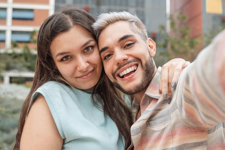 Two young adults with arms around each other.
