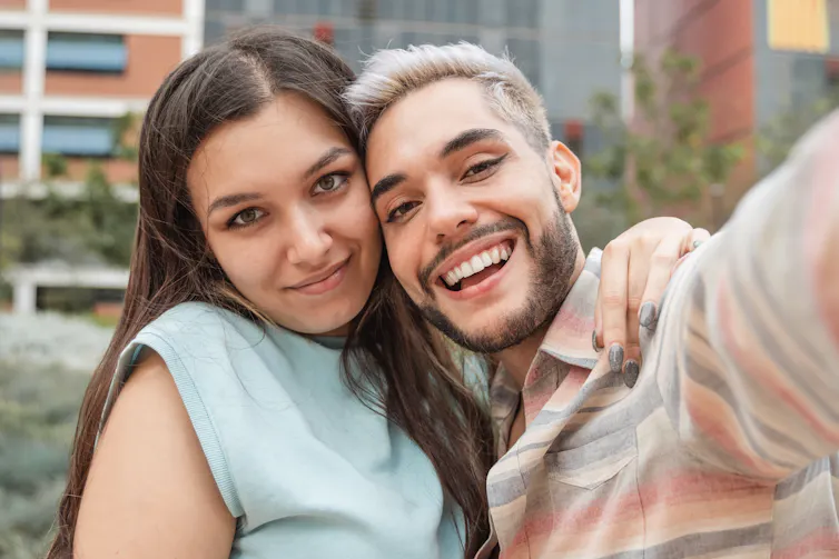 Two young adults with arms around each other.