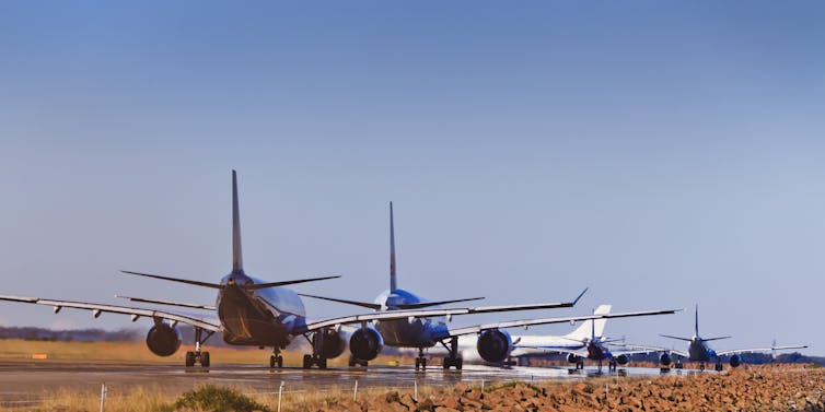 busy airport airfield runway with group of airplanes queueing to depart