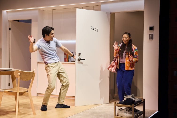 A man ushers a woman into his apartment.