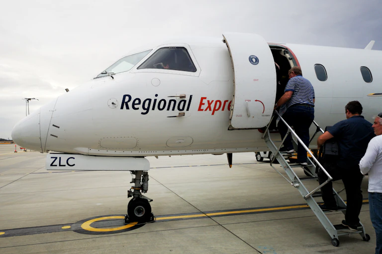 People queuing on tarma to board small aircraft