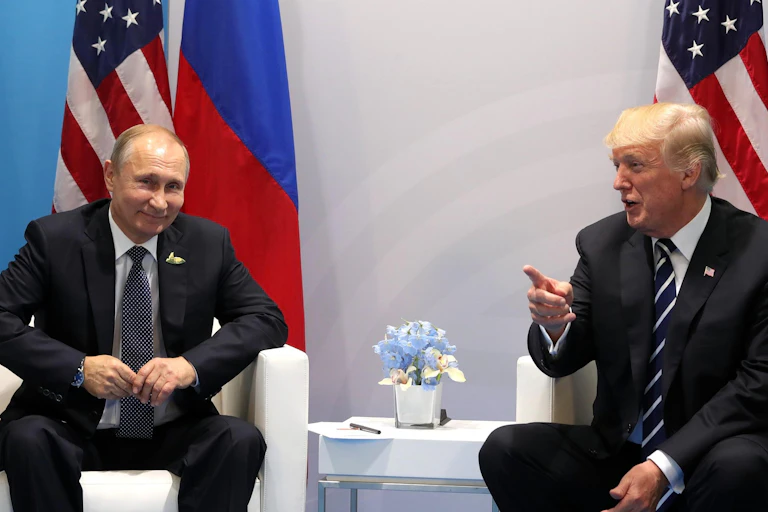 Donald Trump and Vladimir Putin sit next to each other.