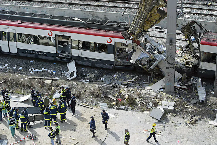 Bodies of victims are evacuated from a partially destroyed train.
