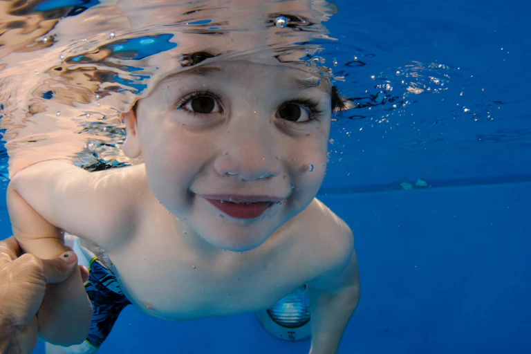 Child swimming with its eyes open underwater