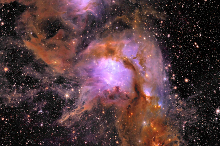 Nébuleuse violette et orangée sur un fond de ciel étoilé.