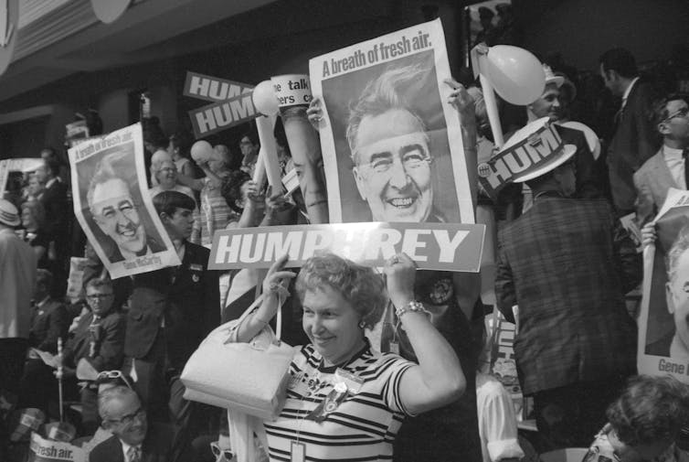 People in a crowd holding candidate signs.