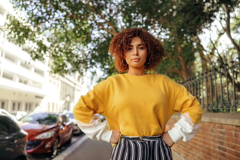 Confident Gen Z black girl standing with hands on hips.
