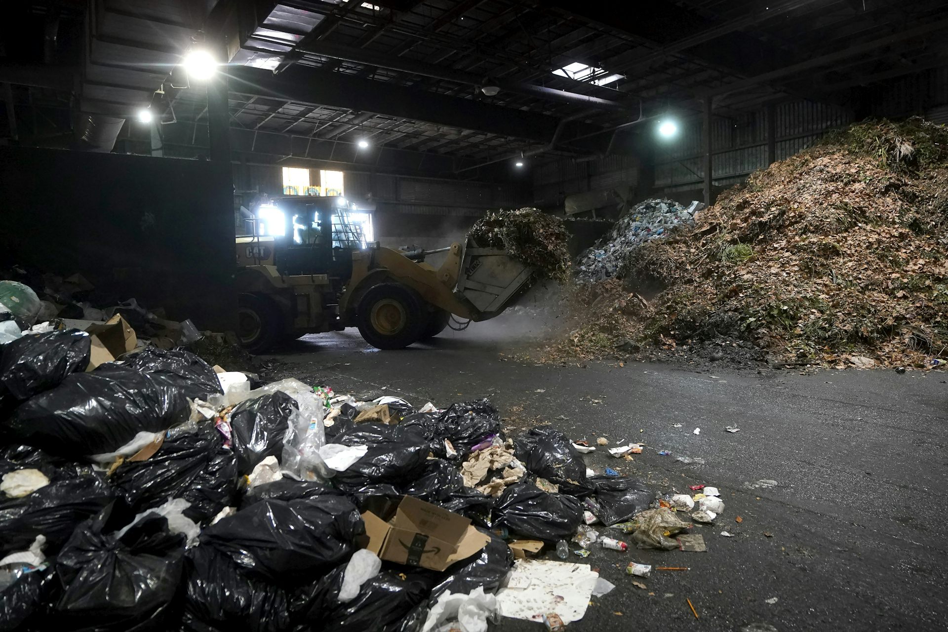 Piles of waste are seen in a warehouse.