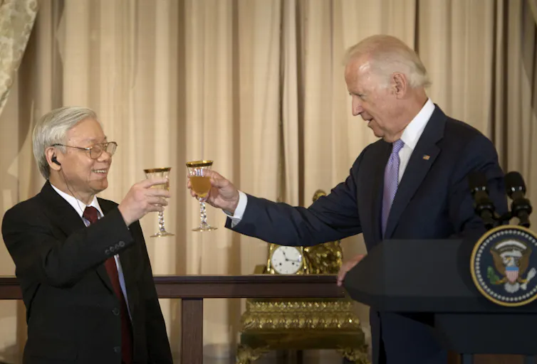 Two men in suits raise glasses.