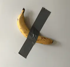 Un plátano pegado a una pared con una cinta adhesiva.