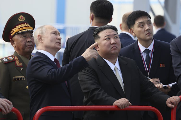 Vladimir Putin and Kim Jong-un examining a launch pad.