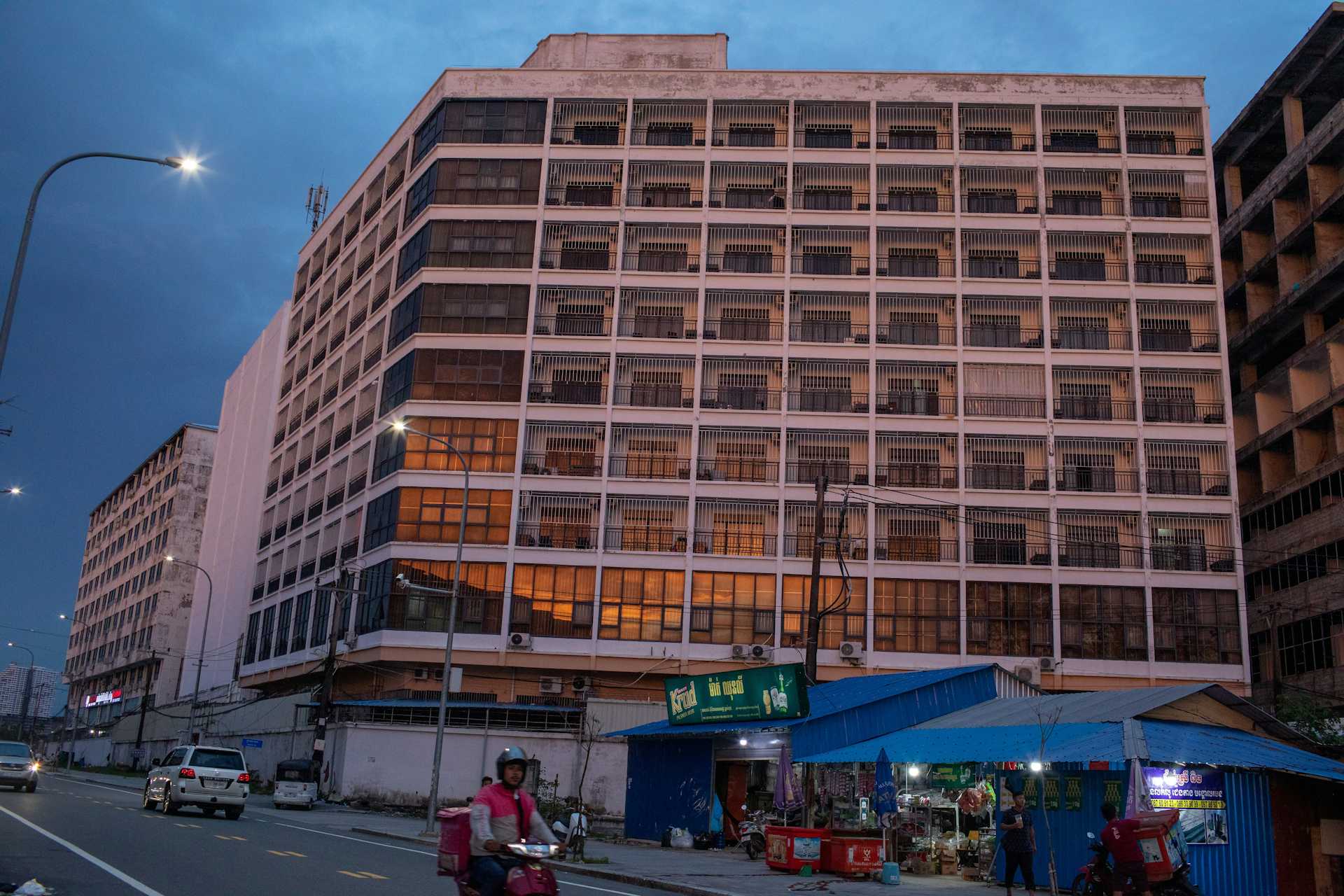 One of the many buildings across Sihanoukville, Cambodia, surrounded by barbed wire with barred windows.