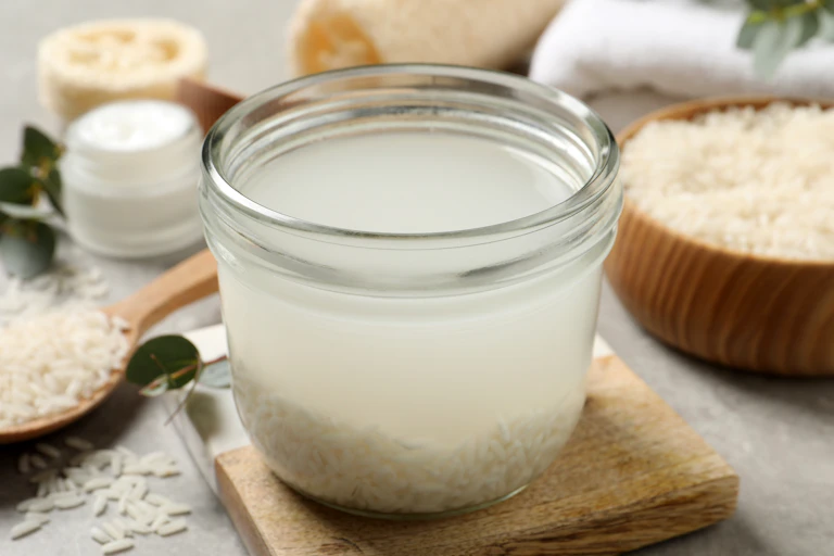 A container with rice and water, with rice in the background.
