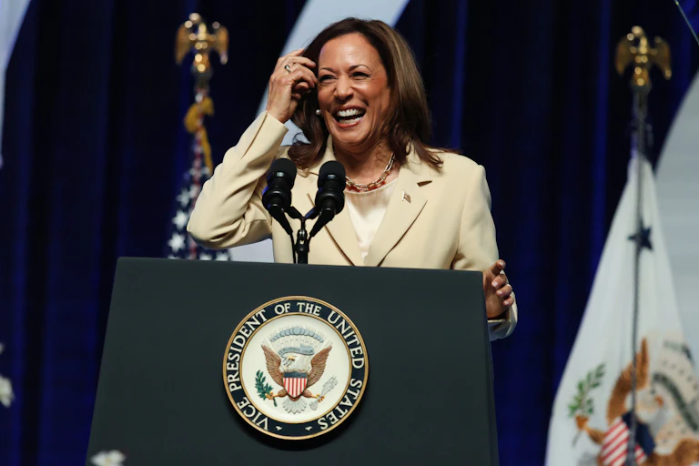 Kamala Harris laughing while speaking at a podium