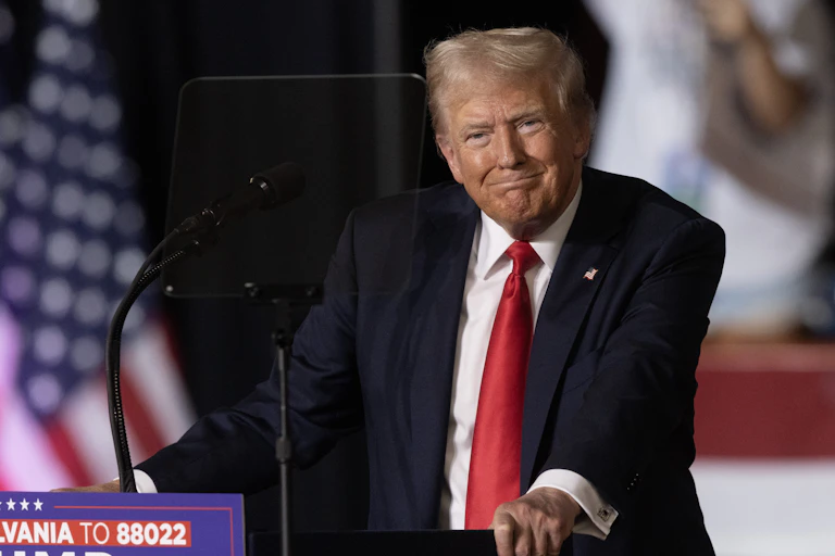 Donald Trump smirking while delivering a speech.