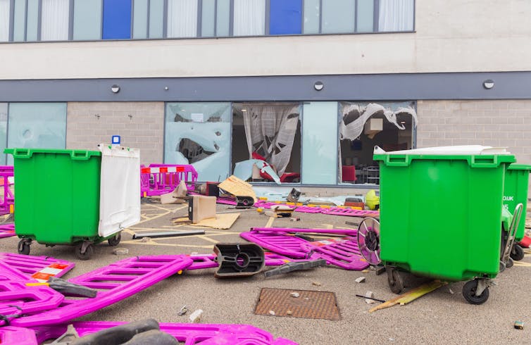 Janelas quebradas e barreiras destruídas no estacionamento de um hotel