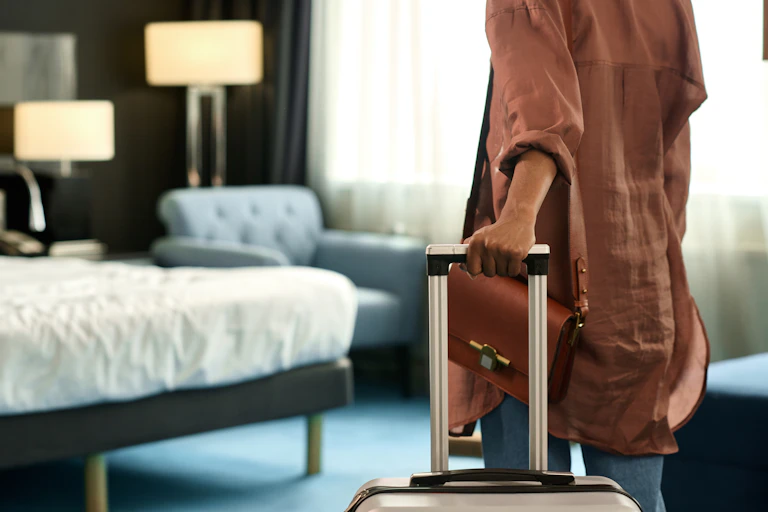 Woman pulling suitcase into hotel room
