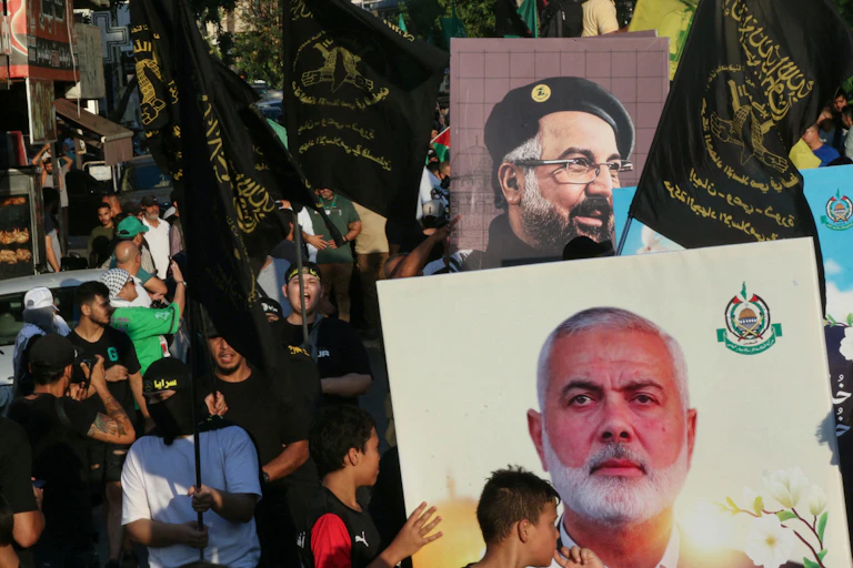 Protesters hold aloft posters with the portraits of two men.