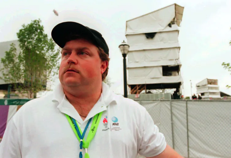 A man in a white polo looks to the left