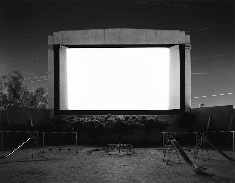 A drive in with a playground. A bright white screen.