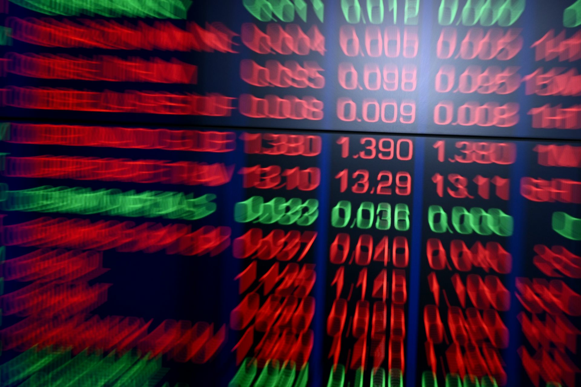 Blurred red stock market symbols and prices on a display