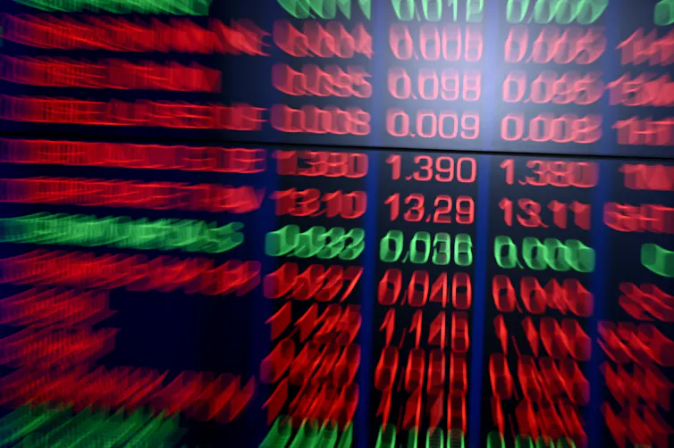 Blurred red stock market symbols and prices on a display