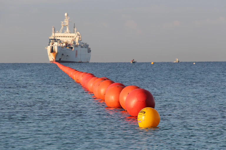 un gros bateau blanc sur la mer en train de poser un câble sous-marin