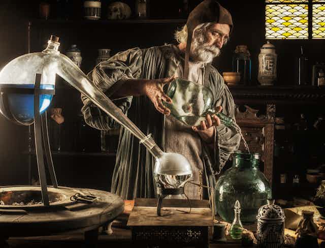 solving problems scientific methodology medieval alchemist working in his lab with flasks in foreground