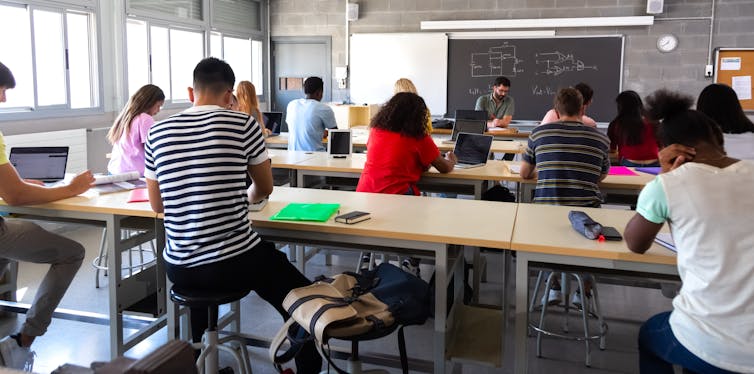 Students in a classroom writing at desks.