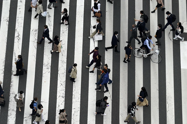 People cross a busy street.