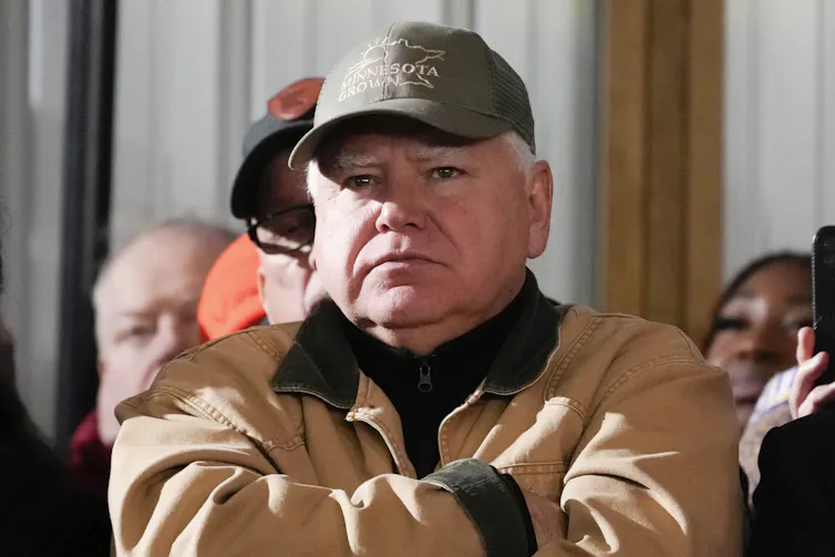 Tim Walz listening to Joe Biden speak.
